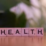 Close-up of Scrabble tiles spelling 'Health' on a wooden table with a blurred background. — Novi automati za igre i trendovi