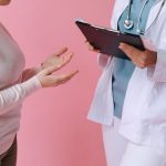 Close-up of a patient consulting a doctor with a clipboard in a medical setting. — Understanding BMI calculations and their r