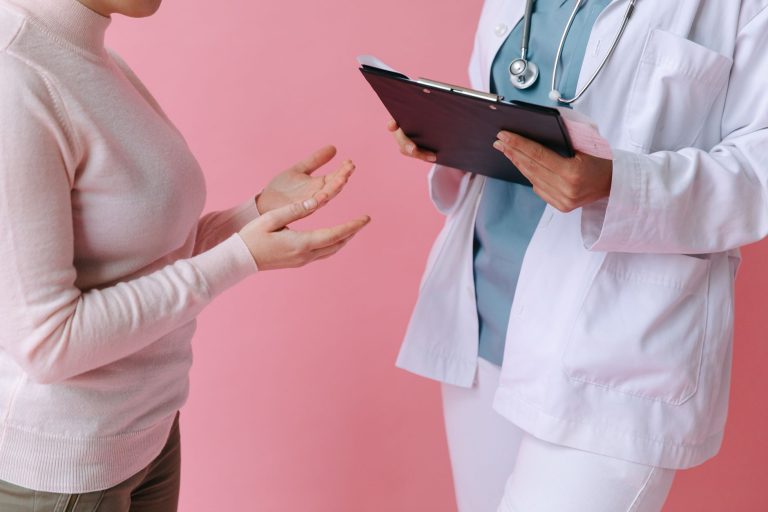 Close-up of a patient consulting a doctor with a clipboard in a medical setting. — Understanding BMI calculations and their r